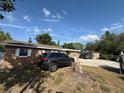A brick home with dark trim and white trim and a vehicle parked in the driveway at 311 Congress Ave, Auburndale, FL 33823