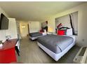 Bright bedroom featuring two beds with stylish gray comforters and a mounted television at 5245 W Irlo Bronson Memorial Hwy # 276, Kissimmee, FL 34746