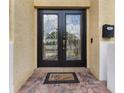Close-up of the beautiful double front doors with decorative glass and brick entryway at 5321 Los Palma Vista Dr, Orlando, FL 32837