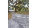 Mature trees and a long cracked concrete driveway enhances the front yard at 6419 Lakeville Rd, Orlando, FL 32818