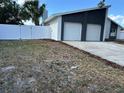 Beautiful home featuring a two-car garage, modern white exterior, and a white privacy fence at 705 Wood Ln, Kissimmee, FL 34759