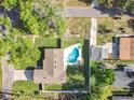 Aerial view of a property featuring a backyard swimming pool and lush green surroundings at 7823 Bell Blvd, Orlando, FL 32810