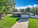 Inviting home with a brick driveway, manicured lawn, and charming front porch seating area at 7823 Bell Blvd, Orlando, FL 32810