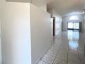 Neutral hallway with ceramic tile flooring that leads to a bright living space at 849 Long Bay Ct, Kissimmee, FL 34741