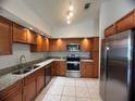 Updated kitchen with stainless steel appliances, granite counters, and wood cabinetry at 849 Long Bay Ct, Kissimmee, FL 34741