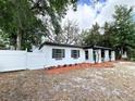 Well-maintained home with a white fence and manicured landscaping at 906 San Domingo Rd, Orlando, FL 32808