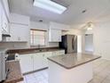 Bright kitchen featuring white cabinets, granite countertops, stainless steel appliances, and a center island at 923 Gascony Ct, Kissimmee, FL 34759