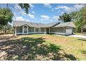 Charming single-story home featuring arched windows, a two-car garage, and a well-maintained lawn at 1100 Anne Elisa Cir, St Cloud, FL 34772