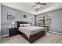 Relaxing main bedroom with tray ceiling, neutral paint, plush carpet, and a view of the trees at 11120 Whistling Pine Way, Orlando, FL 32832