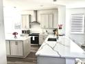 Bright, open kitchen featuring an island, stainless steel appliances, and quartz countertops at 11688 Founders St, Orlando, FL 32832