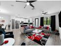 Open-concept living room with modern sofas, stylish rug, and a seamless flow into the kitchen at 1231 Sandwedge St, Davenport, FL 33896