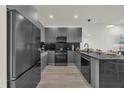 Sleek modern kitchen with stainless steel appliances, dark cabinetry, and ample counter space at 1385 Peaceful Nature Way, Clermont, FL 34714
