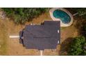 Aerial view of a house with a dark roof and a kidney-shaped pool surrounded by trees and lush greenery at 1400 Florida Ave, St Cloud, FL 34769