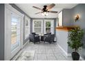 Bright sun room with large windows, tile floors, a ceiling fan, and seating, perfect for relaxation at 1400 Florida Ave, St Cloud, FL 34769