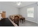 Cozy home office with neutral walls, ceiling fan, natural light and couch for guests at 1532 Angler Ave, Kissimmee, FL 34746