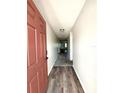 Inviting hallway with wood-look flooring and neutral paint, leading to carpeted area at 158 Violet Ct, Poinciana, FL 34759