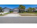 Well-maintained single-story home with a brick driveway, two-car garage, and lush green lawn at 17324 Bracken Fern Ln, Clermont, FL 34714