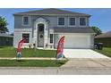 Charming two-story home featuring a well-maintained lawn and an attached two-car garage at 1976 The Oaks Blvd, Kissimmee, FL 34746