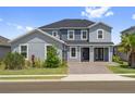 Attractive two-story home with a brick driveway, well-maintained lawn, and symmetrical window placement at 2110 Old Hollow Ln, Clermont, FL 34715