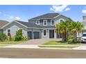 Beautiful two-story home with a three-car garage, brick driveway, and lush landscaping at 2110 Old Hollow Ln, Clermont, FL 34715