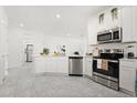 Bright, open kitchen boasts stainless steel appliances and modern white cabinets at 2156 Merrybells Dr, Kissimmee, FL 34746