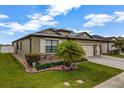 Well-maintained one-story home with a lush landscaped lawn featuring a palm tree and stone accents at 4337 Summer Breeze Way, Kissimmee, FL 34744