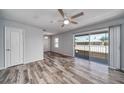 Bright, modern bedroom with light gray walls, wood-look floors, ceiling fan, and sliding doors to a balcony at 525 Georgetown Dr # D, Casselberry, FL 32707