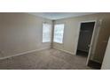 Bedroom with neutral carpet, two windows and an open door to closet at 5501 Rosebriar Way # 111, Orlando, FL 32822