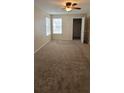 Bedroom featuring neutral carpet, closet, windows, and ceiling fan at 5501 Rosebriar Way # 111, Orlando, FL 32822