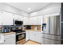 Well-lit kitchen featuring granite countertops, stainless steel appliances and white cabinetry at 5512 Hamlin Close, Davenport, FL 33896