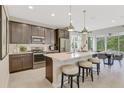 Modern kitchen features an island with stool seating, stainless steel appliances, and ample cabinet space at 6413 Clover St, Lake Hamilton, FL 33851