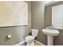 Stylish powder room features a pedestal sink, decorative mirror, and neutral wall paint at 725 Lake Dell Rd, Dundee, FL 33838
