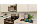 Updated kitchen features stainless steel appliances, sleek countertops, and ample storage space at 733 Lake Dell Rd, Dundee, FL 33838