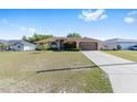Well-maintained single-Gathering home featuring a spacious driveway and lush green lawn at 7431 Sw 129Th Pl, Ocala, FL 34473