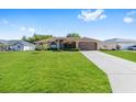 Well-maintained single-Gathering home featuring a spacious driveway and lush green lawn at 7431 Sw 129Th Pl, Ocala, FL 34473
