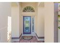 Inviting front door featuring decorative glass and arched transom window at 7431 Sw 129Th Pl, Ocala, FL 34473