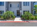 Exterior view of the building entrance surrounded by beautiful landscaping with palm trees and green plants at 7740 Sandy Ridge Dr # 236, Reunion, FL 34747