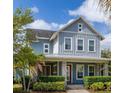 Inviting two-story house featuring a covered porch with stone pillars and beautiful landscaping at 7878 Greengard St, Orlando, FL 32827
