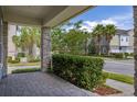 View from the covered front porch showcasing the paver flooring, stone columns, and neighborhood streetscape at 7878 Greengard St, Orlando, FL 32827
