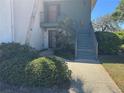 Charming two-story condo featuring mature landscaping, inviting entrance, and a well-maintained pathway at 8 Buck Cir # 8, Haines City, FL 33844