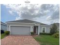 Charming single-story home with a well-manicured lawn and beautiful brick paved driveway at 878 Benjamin Trl, Davenport, FL 33837