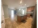 Open kitchen with island, stainless steel appliances, and easy access to the living room at 878 Benjamin Trl, Davenport, FL 33837