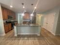 Well-lit kitchen featuring a granite island, stainless steel appliances and ample cabinet space at 878 Benjamin Trl, Davenport, FL 33837