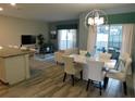 Light-filled dining and living area with stylish light fixture and sliding glass doors to the outdoor area at 9079 Dogleg Dr, Davenport, FL 33896