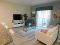 Bright living room featuring modern furniture, a large TV, and access to the outdoors at 9079 Dogleg Dr, Davenport, FL 33896