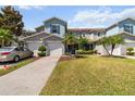 Two-story townhome community featuring well-manicured lawns, an attached one-car garage, and mature palm trees at 1002 Chalcedony St, Kissimmee, FL 34744
