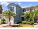 Two-story townhome featuring mature palm trees, neat landscaping, and a well-manicured lawn at 1002 Chalcedony St, Kissimmee, FL 34744