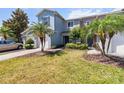 Landscaped lawn featuring a two-story townhome with an attached one-car garage and colorful shrubbery at 1002 Chalcedony St, Kissimmee, FL 34744