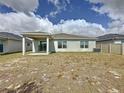 Open backyard with a covered patio, sliding glass doors, and a view of neighboring homes at 119 Summerlin Loop, Haines City, FL 33844