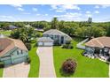 Expansive two-story home featuring a three-car garage, lush lawn, and mature landscaping at 13044 Lakeshore Grove Dr, Winter Garden, FL 34787